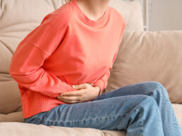 woman holding her stomach in distress