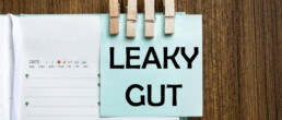 Leaky Gut written on a Post-It note that's pinned to a diary with clothes pegs