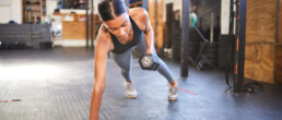 A woman working out with weights in a gym